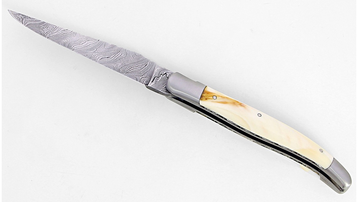 Couteau Laguiole 12 cm double platine, mitres inox brossé en ivoire de phacochère, lame damas carbone.