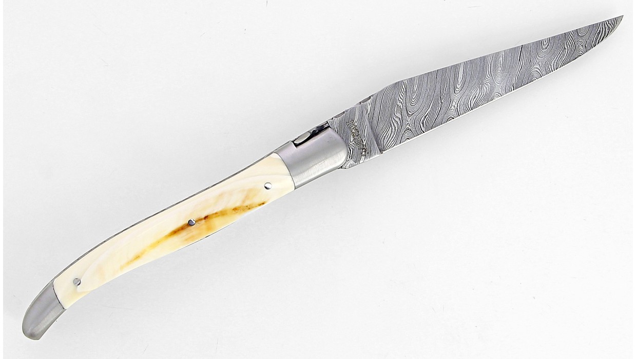 Couteau Laguiole 12 cm double platine, mitres inox brossé en ivoire de phacochère, lame damas carbone.